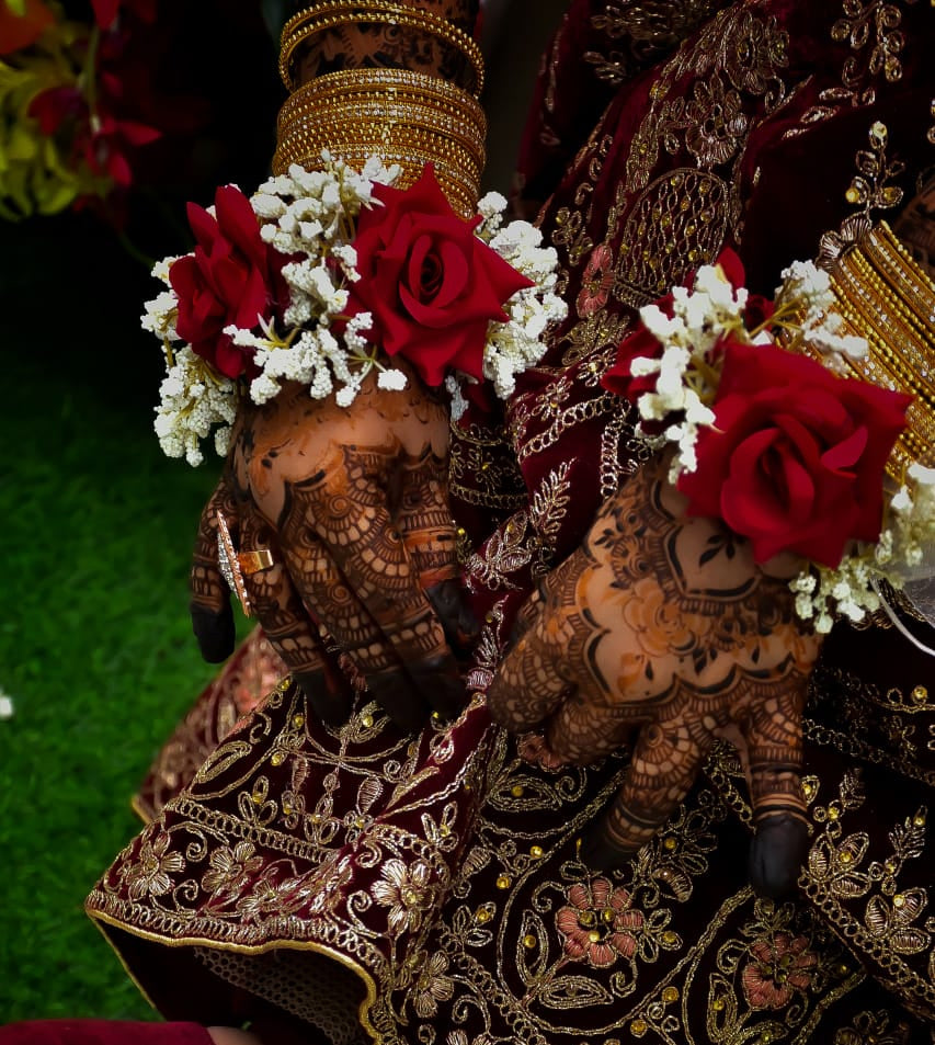 Decorative traditional outfit with intricate patterns and red flowers on a dark background